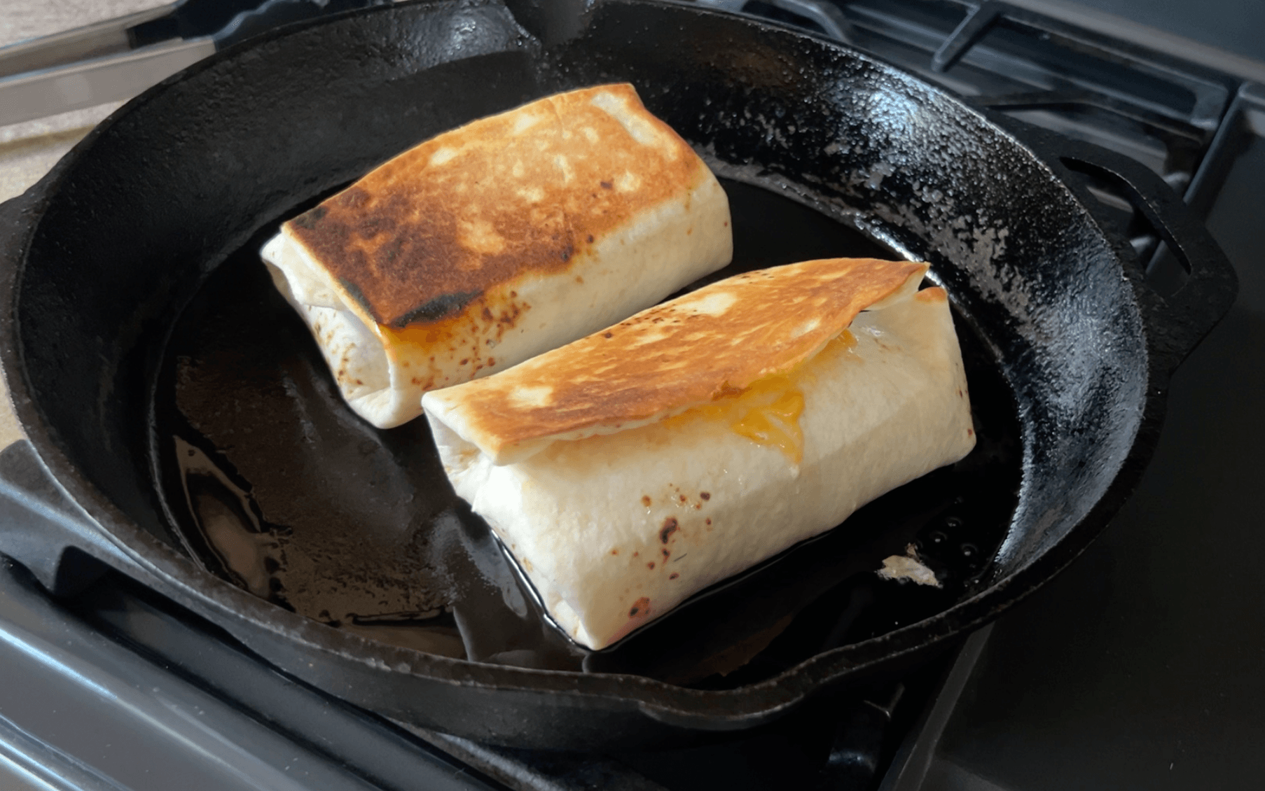 Two wraps toasting in a pan