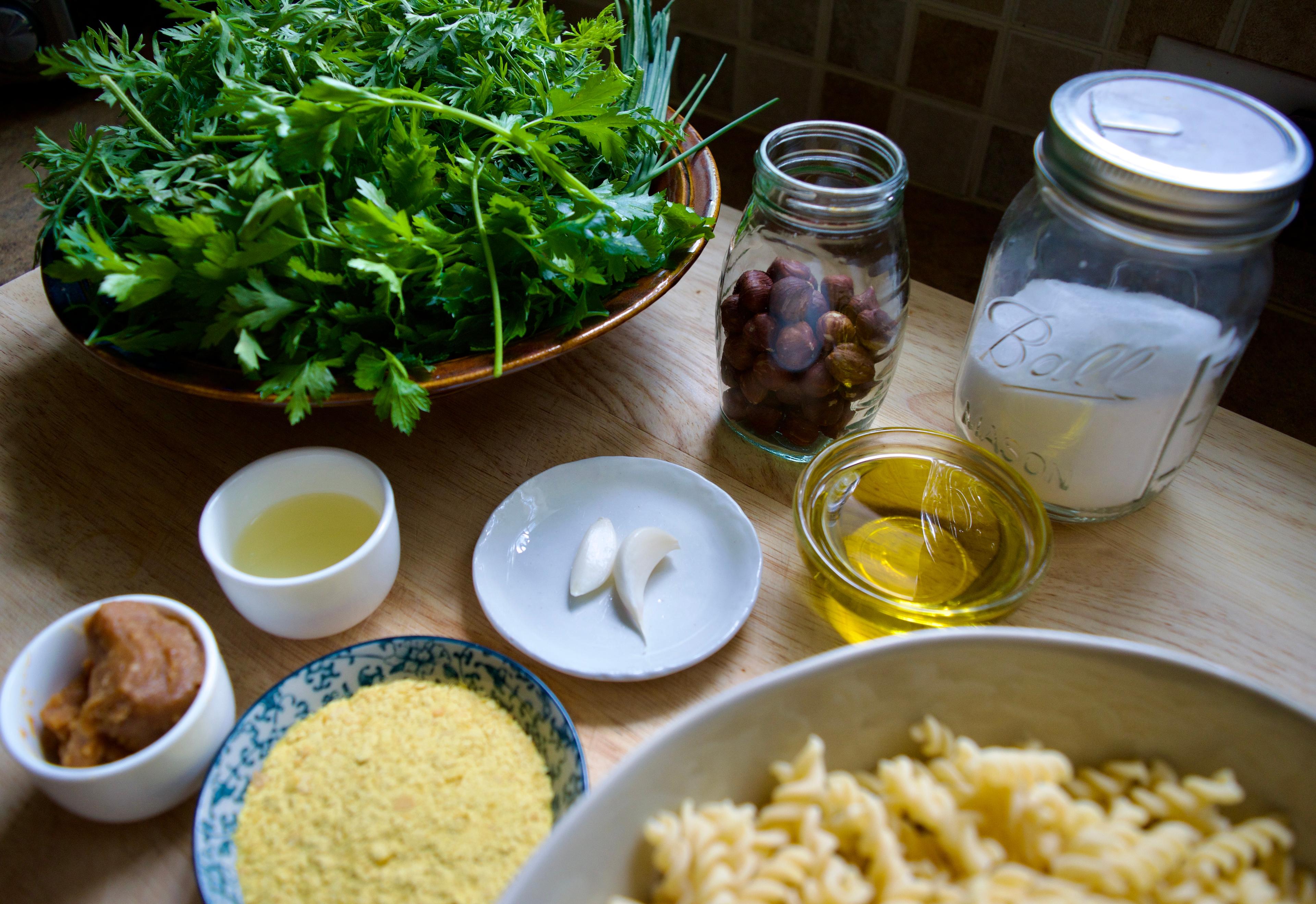 Ingredients - herbs, hazelnuts, garlic, olive oil, pasta, salt