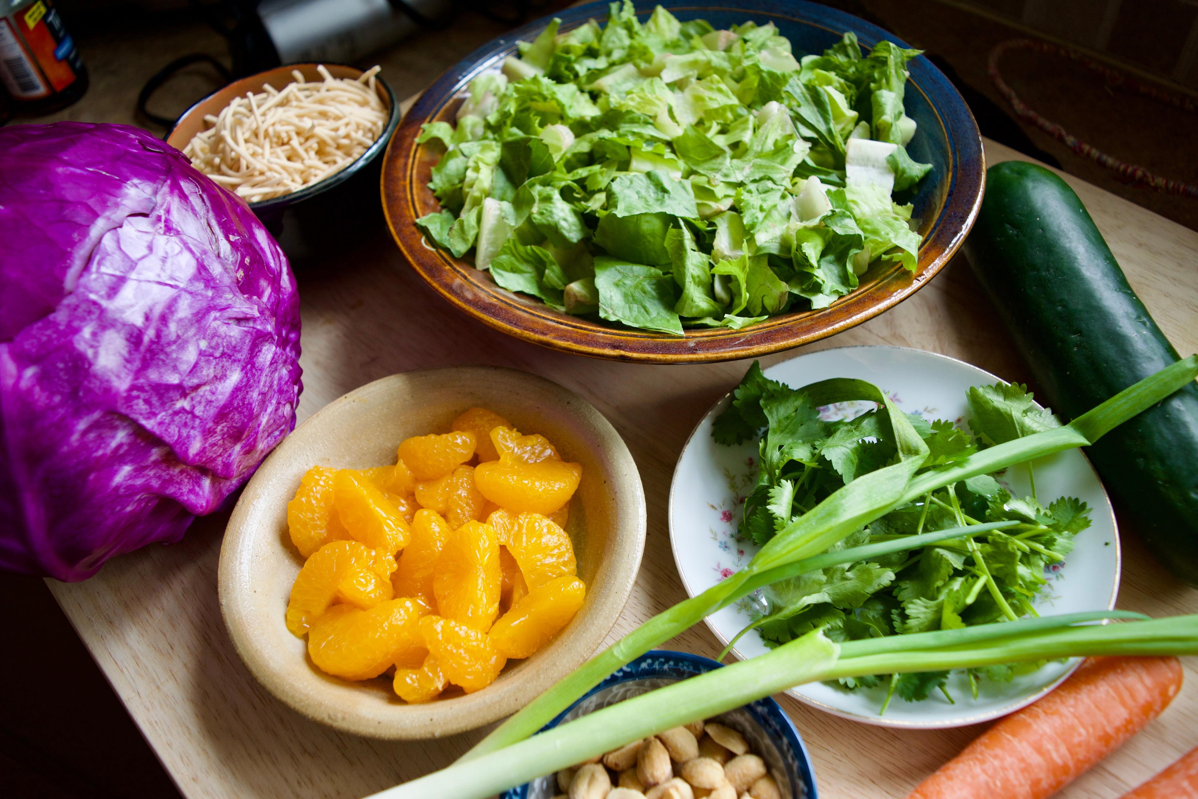 Ingredients - romaine, mandarin oranges, cilantro, peanuts, red cabbage, cucumber, carrots, and chow mein noodles