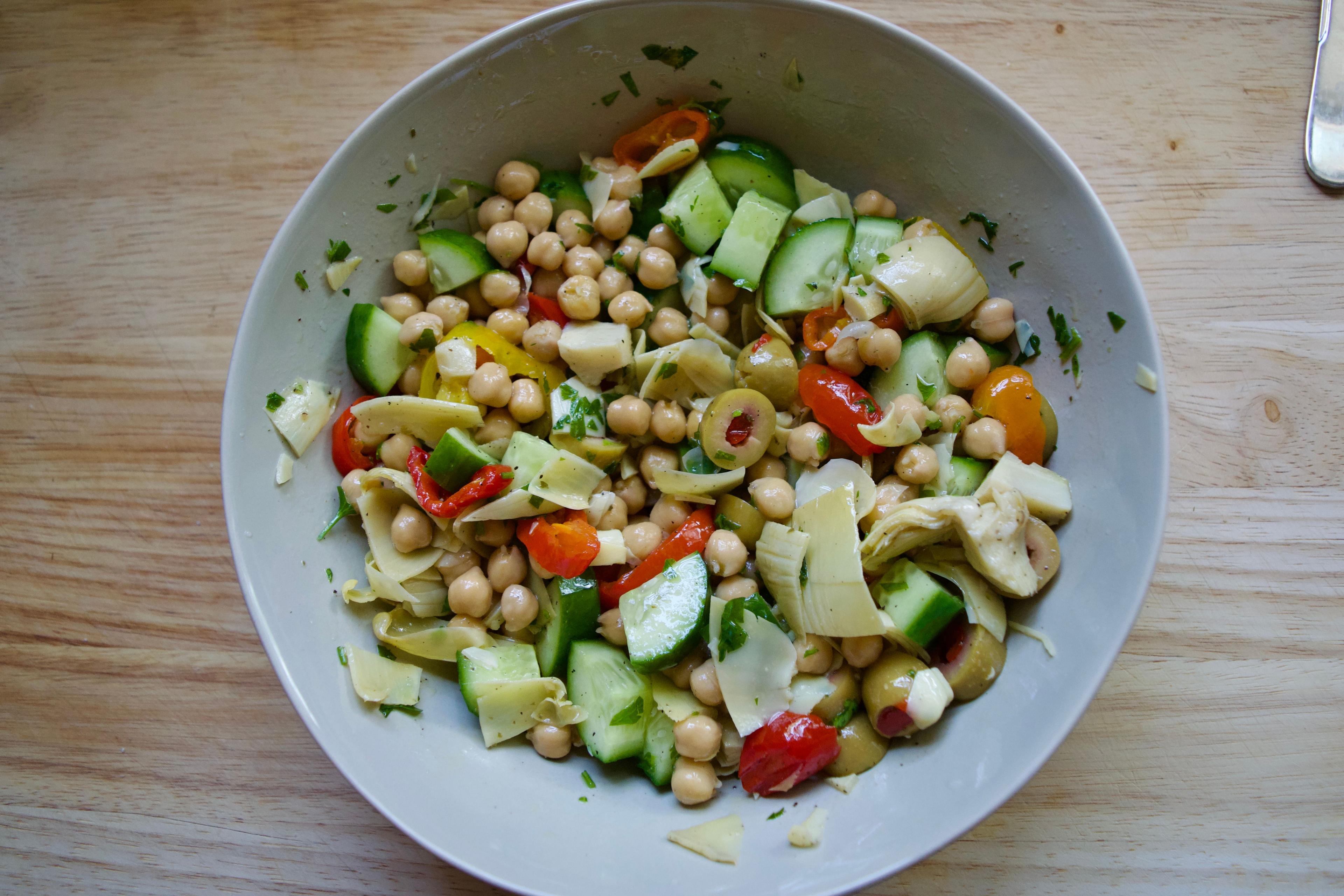 Bowl of chickpea salad with cucumbers and olives